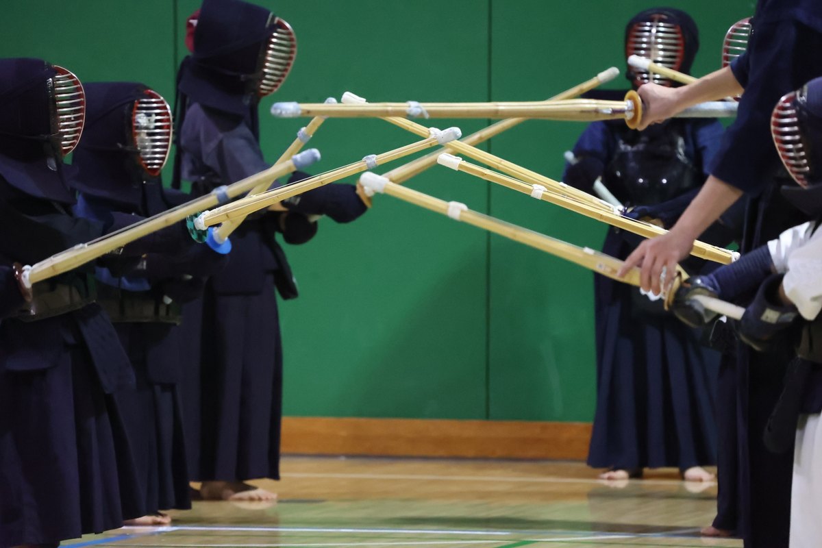 防具を着けた剣道の稽古で、中央に竹刀を差し出して交える様子